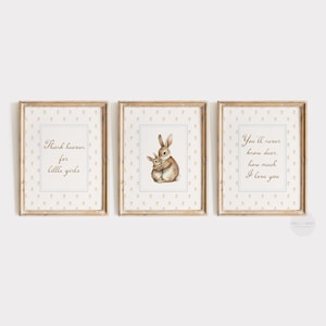 Peut inclure: Un ensemble de trois cadres muraux en bois clair. L'affiche de gauche porte l'inscription Thank heaven for little girls, celle du centre montre deux lapins bruns qui s'enlacent, et celle de droite indique You'll never know dear, how much I love you.