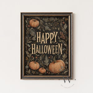 以下が含まれることがあります： 黒い背景に「Happy Halloween」の文字がクリーム色で書かれた額入りのアートプリント。オレンジ色のカボチャと、緑と茶色の植物のイラストが描かれています。