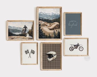 May include: A collection of framed wall art featuring motocross themes. The art includes images of a motocross rider, a motocross bike, checkered flags, a helmet, and mountain landscapes. The color palette includes shades of brown, green, and blue.