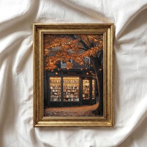 May include: A framed print of a bookstore scene. The artwork shows a cosy bookstore with warm lighting, surrounded by a tree with orange leaves and fairy lights. The frame is gold.