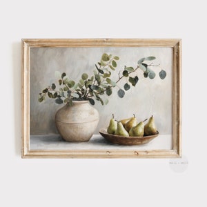 May include: A framed still life painting. It depicts a beige ceramic vase with green foliage, a wooden bowl with green pears, and a neutral backdrop. The frame is made of light, distressed wood.
