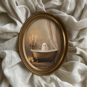 May include: Oval gold framed artwork depicting a ghost in a bathtub with bubbles. The ghost is draped in a white sheet with two black eyes. The bathtub is gold with claw feet. Candles and a candelabra are lit in the background.