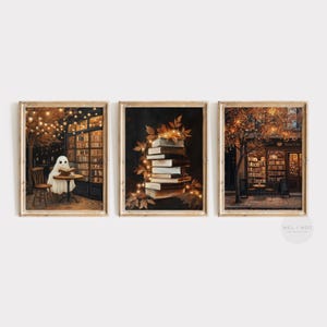 May include: Set of three framed art prints. One print shows a ghost reading at a table in a bookstore. Another shows a stack of books with leaves and lights. The third depicts a bookstore cafe.
