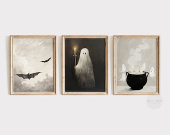 May include: A set of three framed Halloween prints. The first print features a black bat flying in a cloudy sky. The second print shows a white ghost holding a candle. The third print depicts a black cauldron with steam rising from it and several small white ghosts flying around it.