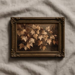 以下が含まれることがあります： 茶色とベージュの色合いの秋の葉の枝を描いた額入りのアートワーク。葉は暗い背景に対して詳細に描かれており、フレームは暗い金色の仕上げで装飾されています。アートワークはニュートラルカラーの生地に表示されています。