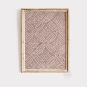 May include: A framed print with a pink and white geometric pattern. The pattern is made up of repeating squares and circles. The frame is a light wood color.