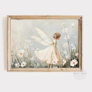 Op de afbeelding: Een ingelijste kunstdruk met een fee met grote doorschijnende vleugels in een crèmekleurige jurk, staand in een veld met witte cosmosbloemen tegen een zachte, gedempte achtergrond. De tekst WELL + WEST staat in de onderste hoek gedrukt.