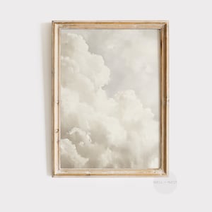 May include: A framed print of a painting depicting a cloudy sky in shades of white and grey. The frame is a light wood colour.