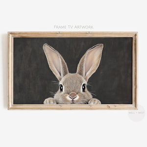 May include: A framed illustration of a brown rabbit peeking out from behind a dark gray background. The rabbit has large ears and a cute, curious expression.