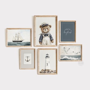 May include: A set of six framed nautical-themed art prints. The prints feature a sailboat, a teddy bear in a sailor outfit, a lighthouse, seagulls, an anchor, and the text "Long Live boyhood". The frames are a light brown color.