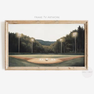 Puede incluir: Obra de arte enmarcada que representa un campo de béisbol al anochecer. La imagen muestra una pelota de béisbol en el montículo del lanzador, con luces de estadio iluminando el campo. El texto "FRAME TV ARTWORK" está en la parte superior.