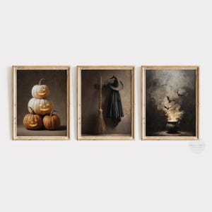 May include: Three framed prints with a Halloween theme. One shows carved pumpkins, another a witch's hat, cloak, and broom, and the third a cauldron with bats and smoke. The prints have a vintage style, with a rustic feel, and are framed in light wood.
