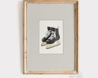 May include: Watercolor print of black ice skates with white laces, set against a striped background. The skates are detailed with visible stitching and metal blades, framed in a gold-toned wooden frame. The artwork is part of the Well + West Art Collection.