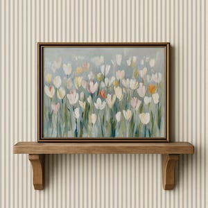 Puede incluir: Un cuadro rectangular enmarcado que presenta un campo impresionista de tulipanes blancos, crema y rosa suave con tallos verdes sobre un fondo azul gris&aacute;ceo apagado. La obra est&aacute; encerrada en un marco fino de color marr&oacute;n oscuro con acabado met&aacute;lico.