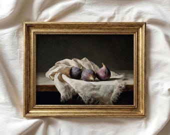 May include: A framed still life painting featuring three ripe figs on a linen cloth. The figs are a deep purple color, with one having a green stem. The painting is in a gold-colored frame.