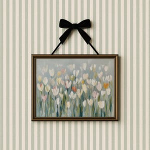 Puede incluir: Una pieza de arte mural rectangular que presenta una pintura impresionista de tulipanes blancos, crema y naranja suave sobre un fondo azul gris&aacute;ceo apagado. La obra est&aacute; enmarcada en un marco de bronce oscuro y cuelga de un lazo de terciopelo negro.