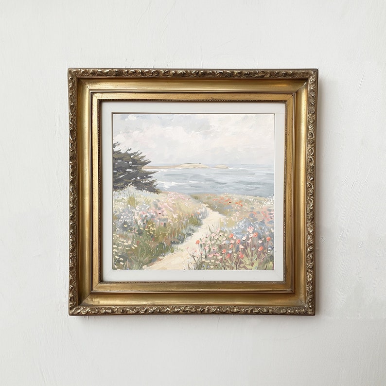 May include: A framed landscape painting depicting a coastal scene. The artwork features a path leading to the ocean, surrounded by wildflowers in shades of pink, red, and yellow. The frame is ornate, gold-colored, and adds a classic touch to the artwork.