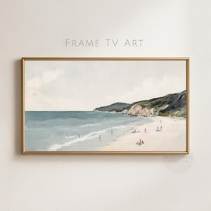 Puede incluir: Una impresión artística enmarcada que representa una escena de playa con un marco dorado. La obra presenta un océano azul claro, una playa de arena y colinas verdes en el fondo. El texto "FRAME TV ART" está en la parte superior.