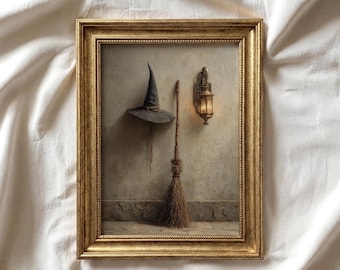 May include: A framed artwork featuring a witch's hat, broom, and wall-mounted lantern. The hat is dark gray with a pointed crown and a wide brim. The broom is made of brown bristles. The lantern emits a warm, inviting glow. The frame is gold.