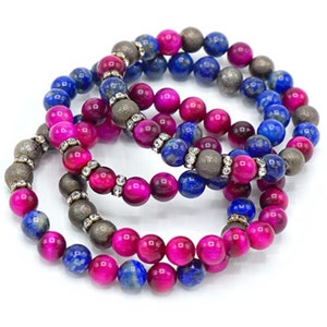 Puede incluir: Conjunto de cuatro pulseras con cuentas de piedras preciosas rosas y azules. Las pulseras están hechas con cuentas de ojo de tigre, lapislázuli y pirita.