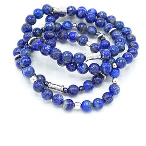 May include: Four layered bracelets made of blue lapis lazuli beads and silver spacers.
