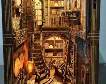 Puede incluir: Un diorama de madera para estantería que representa el interior de una biblioteca de varios niveles con detalles cortados a láser, estanterías en miniatura, una escalera de caracol, una escalera de mano y una iluminación cálida.