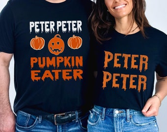 May include: Two black t-shirts with orange text and pumpkin graphics. The first shirt says "Peter Peter Pumpkin Eater" with three pumpkins. The second shirt says "Peter Peter" with the text dripping down.