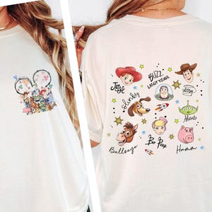 A woman wearing a white t-shirt with various cartoon characters and designs printed on it.