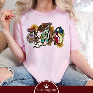 a woman sitting on a couch wearing a pink tshirt