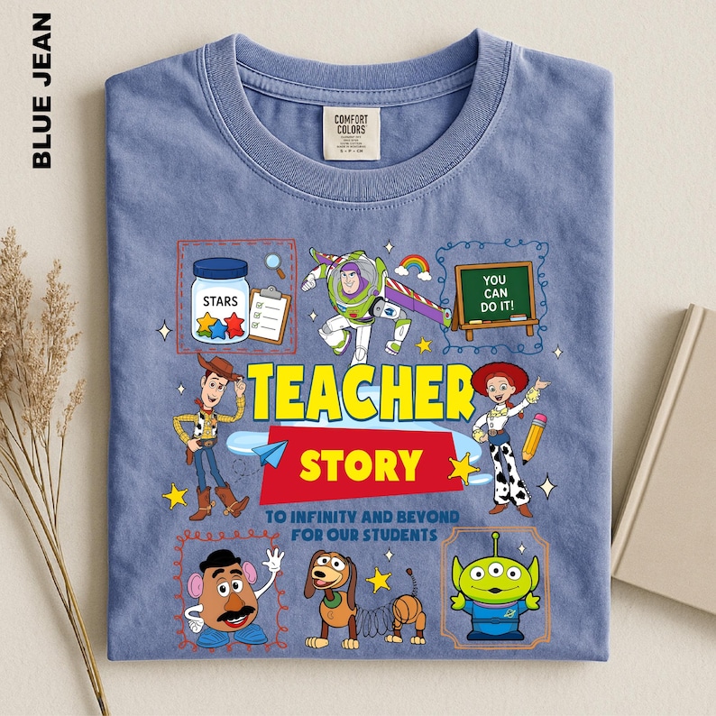 A blue t-shirt with a colorful graphic design featuring characters from the Toy Story movie, including Woody, Buzz Lightyear, and other beloved characters. The design also includes a message that says "Teacher Story" and a quote that says "You can do it!"