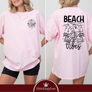 a woman wearing a pink beach vibe shirt