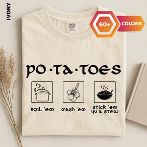 May include: An ivory t-shirt featuring black text that reads "po-ta-toes" above three square icons. The icons depict a pot, a potato masher with potatoes, and a bowl of stew, with the text "boil 'em", "mash 'em", and "stick 'em in a stew" below.