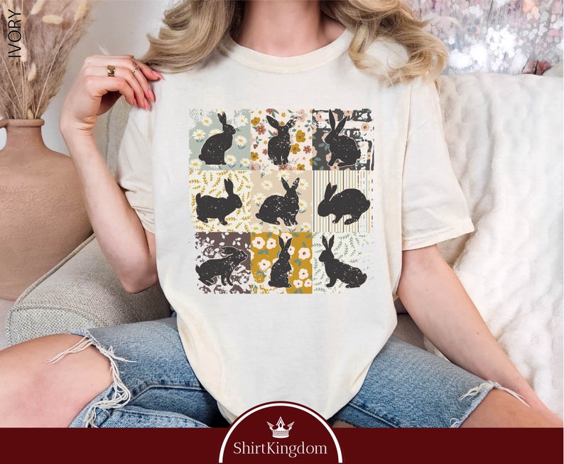 a woman sitting on a couch wearing a t - shirt with cats on it