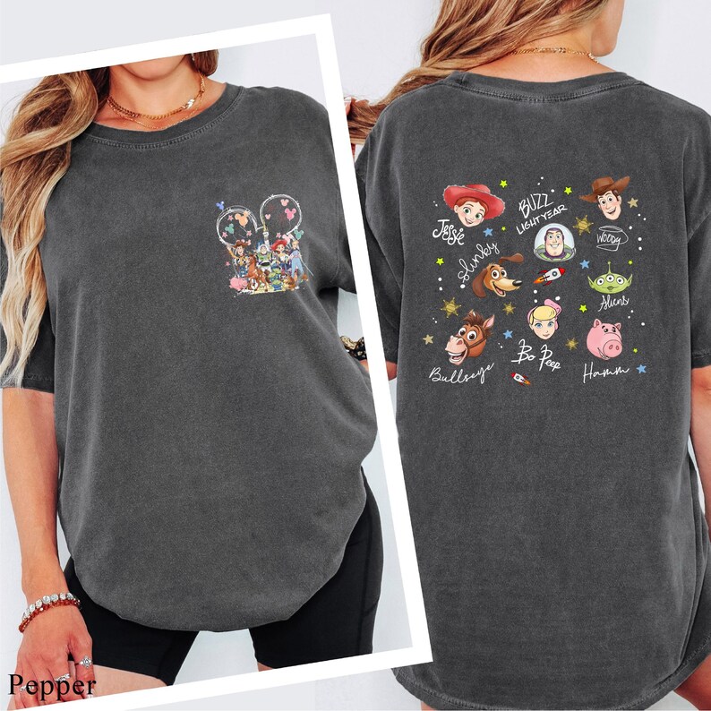 a woman wearing a gray t-shirt with various cartoon characters and text printed on it.