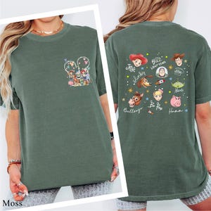A green t-shirt with a collage of cartoon characters and text printed on the back.