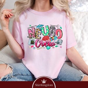 A woman wearing a pink t-shirt with the text "NEURO COUNCIL" printed on it, sitting on a couch.