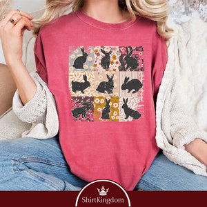 a woman wearing a pink shirt with black cats on it