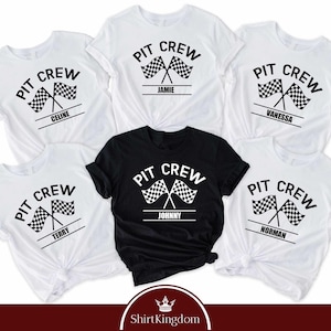 May include: A collection of five short-sleeved t-shirts, four in white and one in black, each featuring a graphic print with the text PIT CREW above two crossed checkered racing flags and a personalized name printed on a horizontal line below.