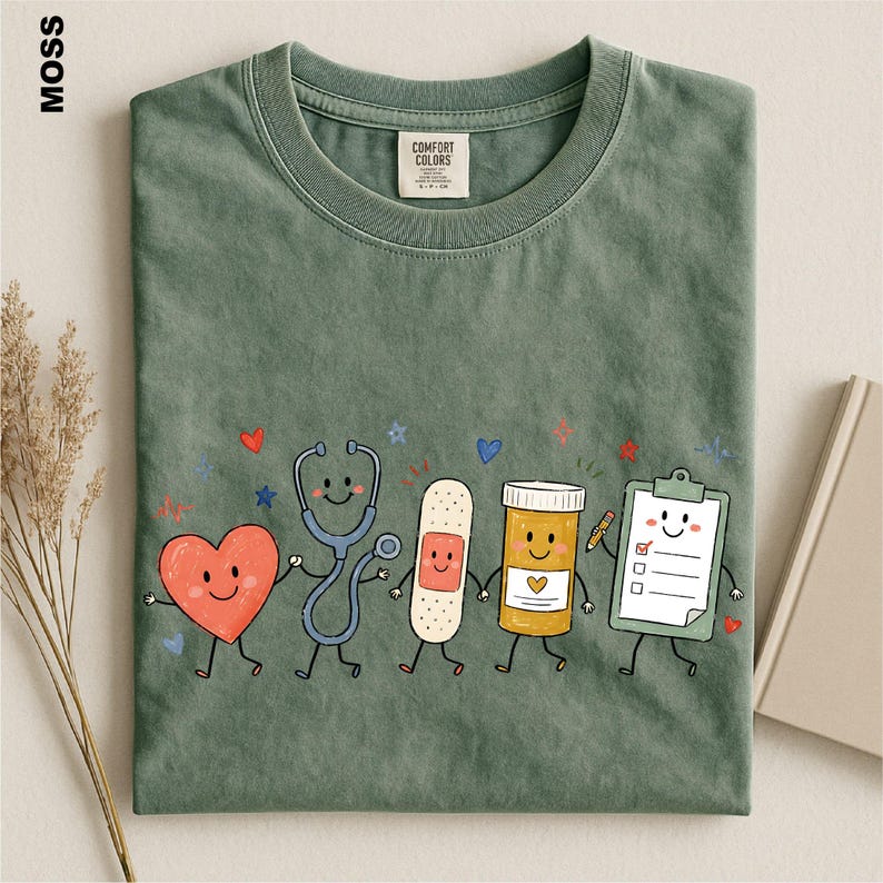 a green t-shirt with a playful design of cartoon-style medical professionals, including a stethoscope, heart, bandage, pill bottle, clipboard, and a smiling face.
