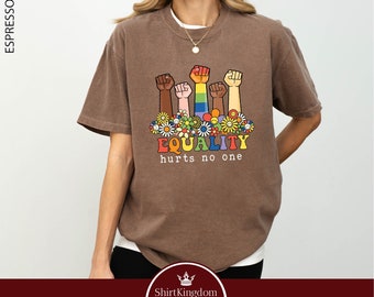 May include: Brown t-shirt with a graphic of raised fists of different skin tones, surrounded by flowers and the text "EQUALITY hurts no one".