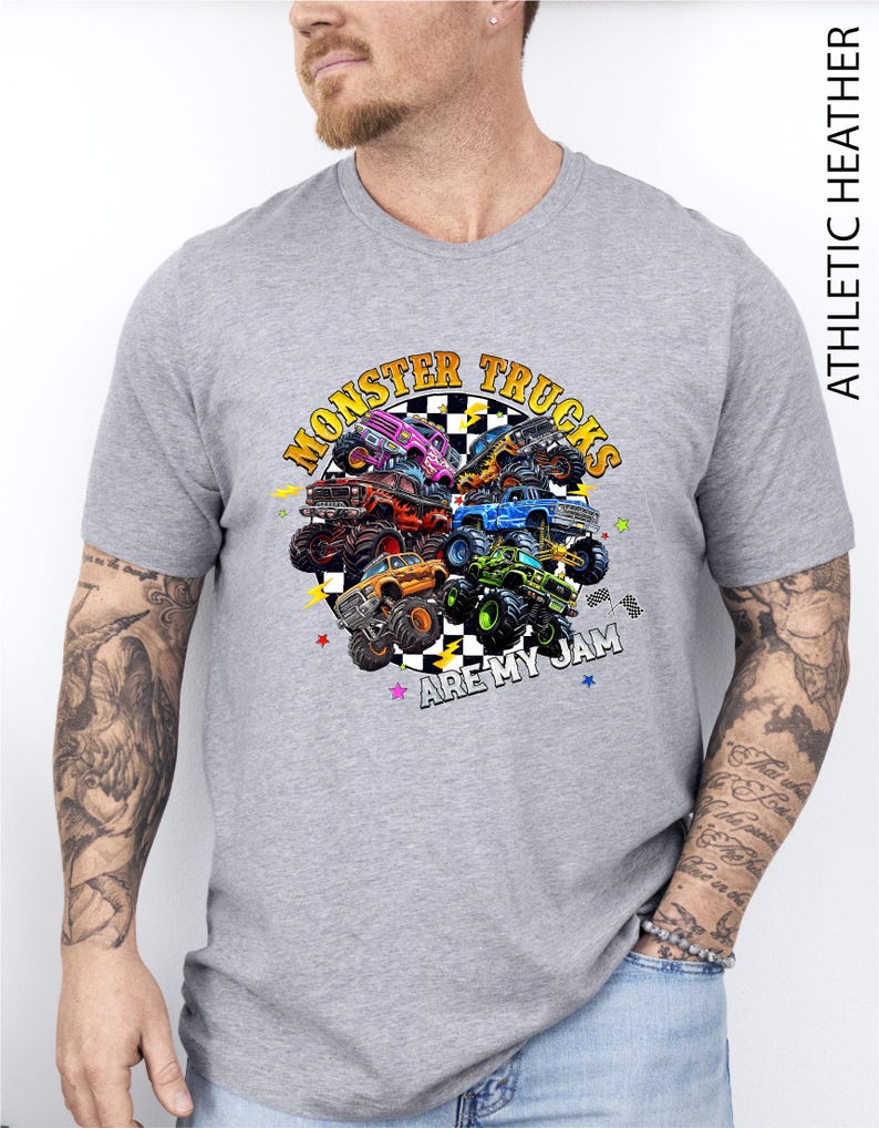 A man wearing a gray t-shirt with a graphic design of various monster trucks.