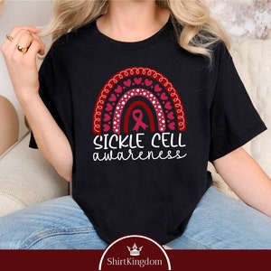 May include: Black t-shirt with a red and white rainbow design and the text "Sickle Cell awareness".