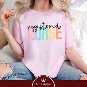 a woman sitting on a couch wearing a pink shirt