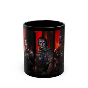 Può includere: Tazza da caffè in ceramica nera con una grafica rossa e nera di tre personaggi di un videogioco. I personaggi indossano equipaggiamento tattico e maschere. Il testo "Call of Duty" è visibile sulla tazza.