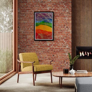 K&ouml;nnte beinhalten: Ein gerahmtes abstraktes Gem&auml;lde mit einem Regenbogen-Farbschema h&auml;ngt an einer Backsteinwand in einem Wohnzimmer. Ein gelber Sessel und ein Holz-Couchtisch stehen im Vordergrund.