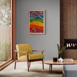 K&ouml;nnte beinhalten: Ein gerahmtes abstraktes Gem&auml;lde mit einem Regenbogen-Farbschema. Das Gem&auml;lde h&auml;ngt an einer grauen Wand in einem Wohnzimmer mit einem gelben Sessel und einem Holz-Couchtisch.