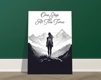 Könnte beinhalten: Schwarz-Weiß-Kunstdruck mit der Silhouette einer Person mit Rucksack auf einem Berg, mit dem Text "One Step At The Time" in eleganter Schrift. Der Hintergrund zeigt eine Bergkette.