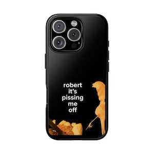 May include: Black phone case with a humorous design. The case features the text "robert it's pissing me off" in white, along with a watercolor illustration of a figure. The case is designed to fit a smartphone.