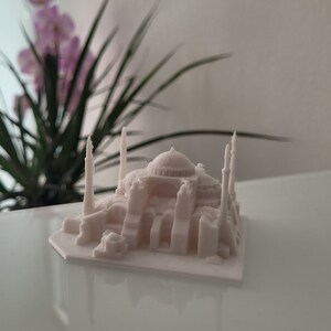 May include: A white 3D printed model of the Hagia Sophia, a famous mosque and former church in Istanbul, Turkey.