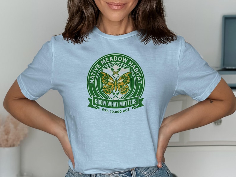 Pale blue t-shirt with green and yellow "Native Meadow Habitat" circular logo.